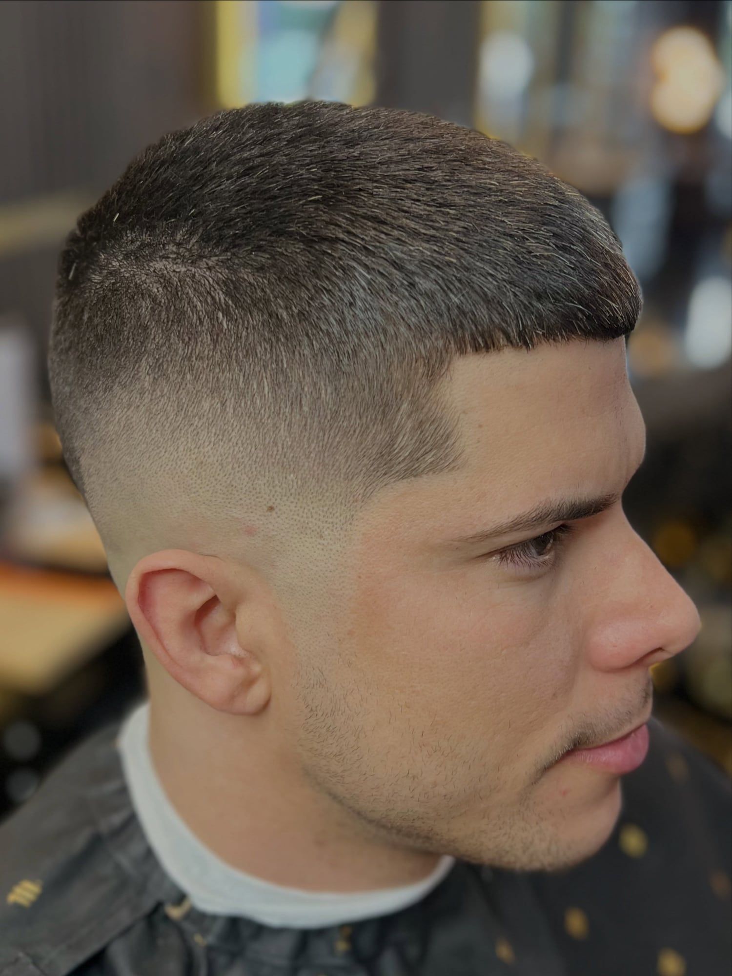 A client with a high skin fade and a short textured crop